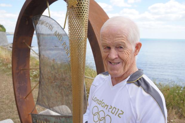 Dorset Echo: Peter Fry with the torch he ran from Chickerell to Wyke through the rain carrying the Olympic fire. Picture: Cristiano Magaglio